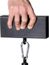 Hand holding a black rectangular weight with a hanging carabiner on a white background